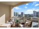 This luxurious balcony has cushioned seating, a small table, and city views at 35 Watergate Dr # 1402, Sarasota, FL 34236