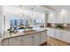 Open kitchen with island, granite countertops, white cabinetry, and views into the dining room at 35 Watergate Dr # 1402, Sarasota, FL 34236