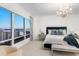 Bright bedroom featuring expansive windows with water views and a stylish chandelier at 35 Watergate Dr # 1402, Sarasota, FL 34236