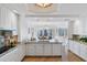 Open kitchen with island, granite countertops, white cabinetry, and views into the dining room at 35 Watergate Dr # 1402, Sarasota, FL 34236