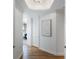 Well-lit hallway with hardwood floors, modern art, and a glimpse of water views at 35 Watergate Dr # 1402, Sarasota, FL 34236