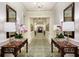 Elegant hallway with decorative tables, lamps, orchids, mirrors and chandelier lighting at 35 Watergate Dr # 1402, Sarasota, FL 34236