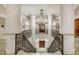 A stunning ornate staircase and wrought iron railing beneath a dazzling chandelier in a luxury building at 35 Watergate Dr # 1402, Sarasota, FL 34236