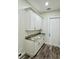 Convenient laundry room features ample cabinetry, granite countertop, and sleek wood-look flooring at 3525 Mcintosh Rd, Sarasota, FL 34232