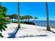 Secluded beach with lounge chairs and trees provides a relaxing outdoor escape for residents at 384 Aruba Cir # 103, Bradenton, FL 34209