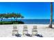 Beautiful beach with chairs, trees, and stunning water views; perfect for relaxation and enjoying the scenery at 384 Aruba Cir # 103, Bradenton, FL 34209