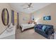 Bedroom with a bed, love seat, ceiling fan and coastal-themed decor at 384 Aruba Cir # 103, Bradenton, FL 34209
