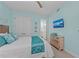 A bright bedroom featuring coastal-themed decor, a ceiling fan, and a wall-mounted TV at 384 Aruba Cir # 103, Bradenton, FL 34209