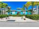 Inviting blue clubhouse with manicured landscaping, featuring a welcoming entrance, white rock and hedge border at 384 Aruba Cir # 103, Bradenton, FL 34209