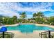 Resort-style community pool with lounge chairs, lush landscaping, and clear blue skies for relaxation at 384 Aruba Cir # 103, Bradenton, FL 34209