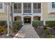 Inviting entrance to the Banana Wind condos with lush landscaping and charming brick pathway at 384 Aruba Cir # 103, Bradenton, FL 34209
