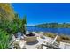 Cozy fire pit area overlooking a serene lake, surrounded by comfortable seating and lush landscaping at 384 Aruba Cir # 103, Bradenton, FL 34209