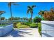 Manicured garden landscape offering tranquil views with multiple palm trees and a glimpse of the water at 384 Aruba Cir # 103, Bradenton, FL 34209