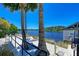 Picturesque lakeside relaxation spot with a hammock strung between palm trees, offering tranquil waterfront views at 384 Aruba Cir # 103, Bradenton, FL 34209