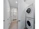 Convenient laundry area with stacked washer and dryer near a hallway with light wood-look flooring at 384 Aruba Cir # 103, Bradenton, FL 34209
