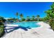 Community pool area with palm trees, lounge chairs, and beachfront access at 384 Aruba Cir # 103, Bradenton, FL 34209
