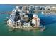 Amazing aerial of a waterfront condo with dock, lush tropical landscaping, and beautiful city skyline at 400 Golden Gate Pt # 51 & 52, Sarasota, FL 34236