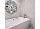 Close-up on a modern white bathtub with a geometric accent tile surround at 400 Golden Gate Pt # 51 & 52, Sarasota, FL 34236