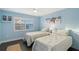 Bright bedroom featuring two beds with blue walls and a view from the shuttered windows at 400 Golden Gate Pt # 51 & 52, Sarasota, FL 34236