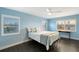A cozy bedroom with light blue walls, hardwood floors, and natural light from shuttered windows at 400 Golden Gate Pt # 51 & 52, Sarasota, FL 34236