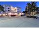 Stunning building exterior with lush landscaping, covered parking, and elegant design features at twilight at 400 Golden Gate Pt # 51 & 52, Sarasota, FL 34236