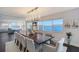 Elegant dining room featuring a stylish chandelier, large windows with water views, and seating for eight at 400 Golden Gate Pt # 51 & 52, Sarasota, FL 34236