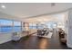 Open dining area with dark wood floors, modern lighting, and beautiful waterfront views at 400 Golden Gate Pt # 51 & 52, Sarasota, FL 34236