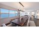 Sophisticated dining room featuring modern lighting, a large table for ten, and breathtaking water views at 400 Golden Gate Pt # 51 & 52, Sarasota, FL 34236