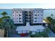 Exterior of a updated multi-story condo with covered parking, balconies, and lush landscaping at 400 Golden Gate Pt # 51 & 52, Sarasota, FL 34236