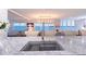Kitchen island features a stainless sink and faucet with an open view of the dining area and water at 400 Golden Gate Pt # 51 & 52, Sarasota, FL 34236