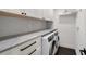 Bright laundry room features modern cabinets, a gray countertop, and a front-loading washer and dryer at 400 Golden Gate Pt # 51 & 52, Sarasota, FL 34236