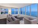 Modern living room with plush seating and expansive windows showcasing waterfront views at 400 Golden Gate Pt # 51 & 52, Sarasota, FL 34236