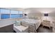 Comfortable main bedroom featuring a queen bed, sitting area, and serene waterfront view at 400 Golden Gate Pt # 51 & 52, Sarasota, FL 34236