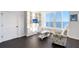 Well-lit main bedroom with a built-in bookcase, sitting chair, and scenic water views at 400 Golden Gate Pt # 51 & 52, Sarasota, FL 34236