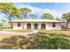Charming single-story home featuring arched windows, a walkway, mature trees, and well-maintained landscaping at 411 S Oxford Dr # 411, Nokomis, FL 34275