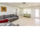 Bright living room with tile flooring, grey couch, and white shelving at 411 S Oxford Dr # 411, Nokomis, FL 34275