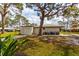 Lovely home featuring an attached garage, mature trees, and a patio area with comfortable seating at 411 S Oxford Dr # 411, Nokomis, FL 34275