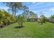 Spacious backyard with lush green grass and mature landscaping, showcasing the home's exterior and outdoor living space at 4320 Bent Tree Blvd, Sarasota, FL 34241