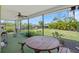 Screened patio featuring a ceiling fan, garden view, and outdoor seating including a wooden picnic table at 4320 Bent Tree Blvd, Sarasota, FL 34241