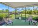 Enclosed patio area with two chairs and a view of landscaped yard at 4320 Bent Tree Blvd, Sarasota, FL 34241