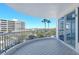 Exterior balcony featuring tile flooring, metal railing, and views of lush landscaping and nearby buildings at 455 Longboat Club Rd # 407, Longboat Key, FL 34228