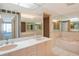 Well-lit bathroom featuring a double vanity and a separate bathtub at 455 Longboat Club Rd # 407, Longboat Key, FL 34228