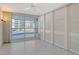 Light filled bedroom with tile floor, built in storage and sliding glass door access to outdoor balcony at 455 Longboat Club Rd # 407, Longboat Key, FL 34228