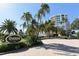 Beautifully landscaped entrance to The Pierre condo building with palm trees at 455 Longboat Club Rd # 407, Longboat Key, FL 34228