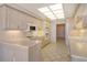 Bright kitchen featuring light wood cabinetry, white countertops, and tile flooring at 455 Longboat Club Rd # 407, Longboat Key, FL 34228