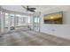 Bright living room featuring large windows, balcony access, and decorative ceiling fan at 455 Longboat Club Rd # 407, Longboat Key, FL 34228