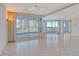 Bright living room boasting tile flooring, large windows and sliding glass door to outside balcony at 455 Longboat Club Rd # 407, Longboat Key, FL 34228
