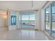 Living room with tile floors, lots of natural light, and sliding glass doors leading to the balcony at 455 Longboat Club Rd # 407, Longboat Key, FL 34228