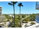 Scenic view from a balcony overlooking lush greenery, palm trees, and buildings on a sunny day at 455 Longboat Club Rd # 407, Longboat Key, FL 34228