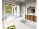 Primary bathroom features a soaking tub, walk-in shower, wood vanity, and an exit to the patio at 4644 Higel Ave, Sarasota, FL 34242